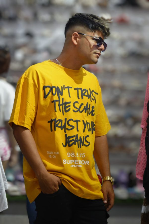 Camiseta amarilla con la frase "DON'T TRUST THE SCALE TRUST YOUR JEANS" (No confíes en la báscula, confía en tus jeans).