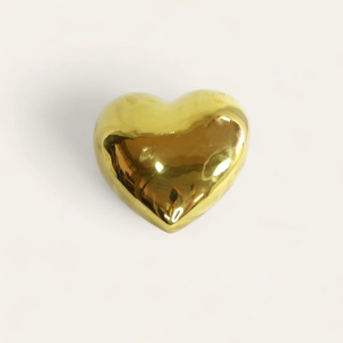 Corazón decorativo de porcelana de color dorado.