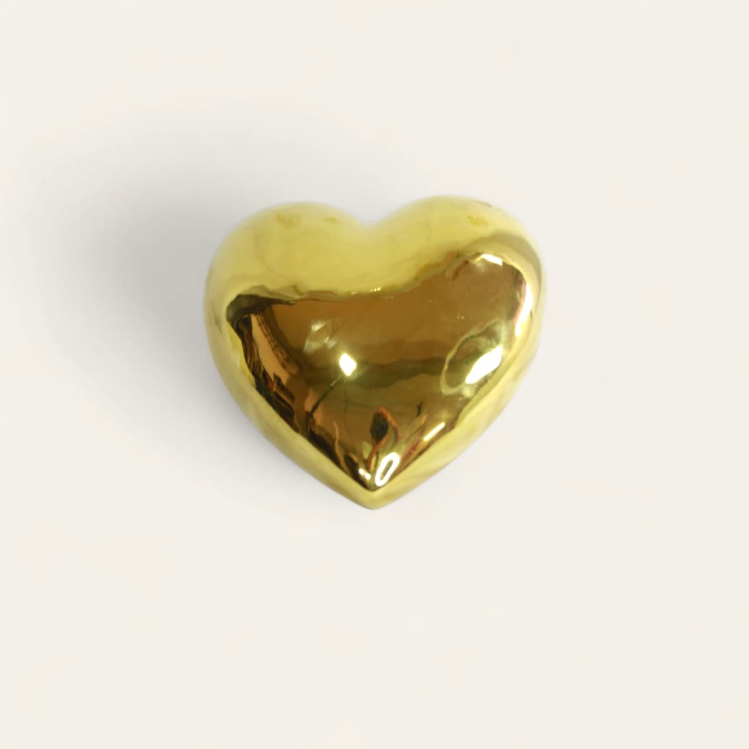 Corazón decorativo de porcelana de color dorado.