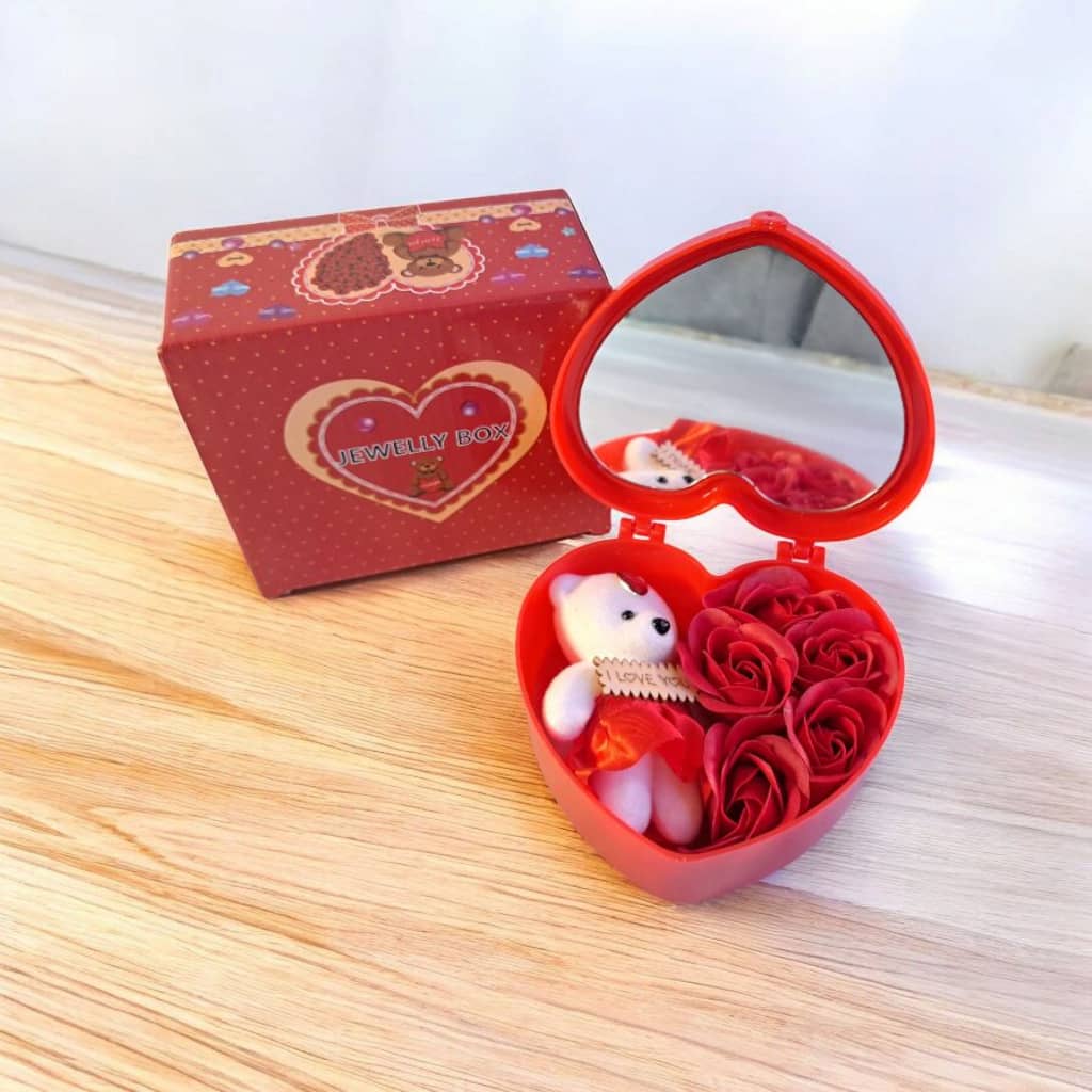 Caja de regalo con forma de corazón que contiene un osito de peluche y rosas eternas de jabón.
