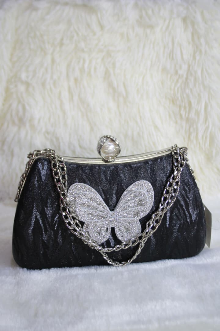 Cartera de noche con asa de cadena y broche de mariposa con diamantes